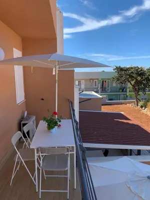 a table and chairs with an umbrella on a balcony at Le Case Vacanze di Federico in Terrasini