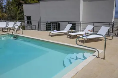 a group of chairs and a swimming pool at Kafara Resort- Villas and Pool by Lisca Bianca Rental in Santa Flavia