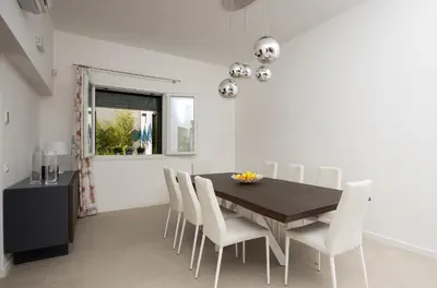 a dining room with a black table and white chairs at Kafara Resort- Villas and Pool by Lisca Bianca Rental in Santa Flavia