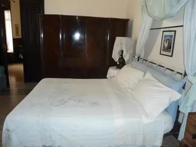 a bedroom with a white bed with a wooden headboard at Rosella Bianchi in Palermo