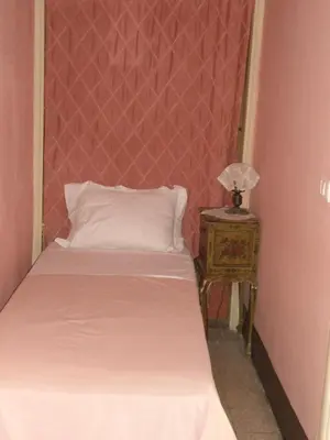 a bedroom with a bed and a table with a lamp at Rosella Bianchi in Palermo