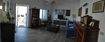 a living room with a blue couch and a table at La casa di Giulio - holiday home in Isola delle Femmine