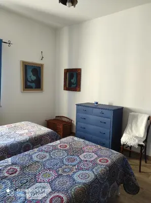 a bedroom with two beds and a blue dresser at La casa di Giulio - holiday home in Isola delle Femmine