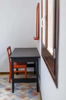 a black table and a chair next to a window at SanvitoTour - Oasi nel Mare in San Vito lo Capo