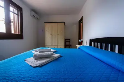 a blue bed with towels sitting on top of it at SanvitoTour - Oasi nel Mare in San Vito lo Capo