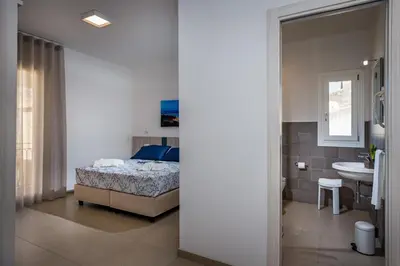 a bedroom with a bed and a bathroom with a sink at Affittacamere Nanà in Castellammare del Golfo