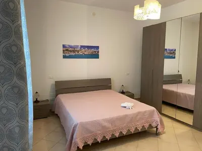 a bedroom with a bed and a mirror at Appartamento Sunrise in San Vito lo Capo