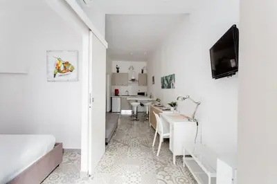 a white room with a bed and a dining room at Sweet home Ballaro' in Palermo