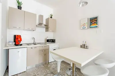 a kitchen with white cabinets and a white table at Sweet home Ballaro' in Palermo