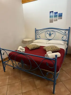 a bed with a red blanket and pillows on it at Cartari Apartment in Palermo