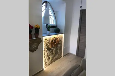 a living room with a stone fireplace with a window at casa vacanza roberto in Palermo