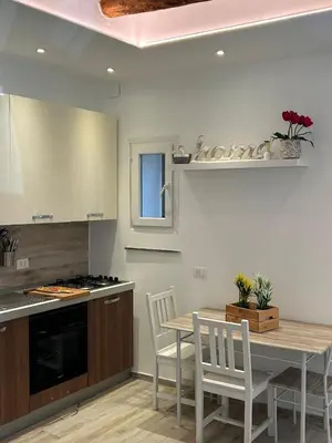 a kitchen with a table and a table and chairs at casa vacanza roberto in Palermo