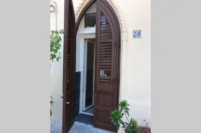 a wooden door on a building with a window at casa vacanza roberto in Palermo