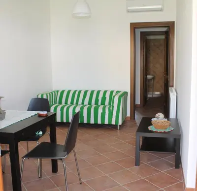 a living room with a couch and a table and chairs at Campofelice Holidays in Campofelice di Roccella