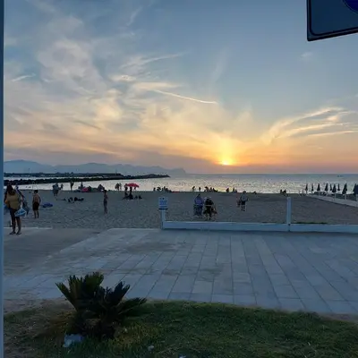 a group of people on the beach at sunset at Villa Torre Magaggiari in Cinisi