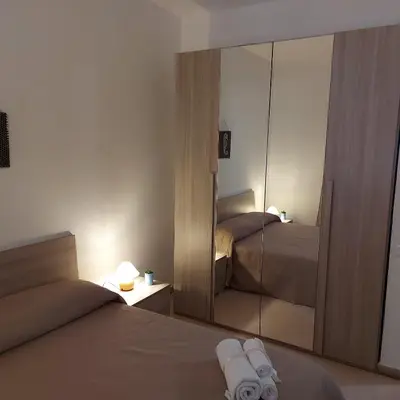 a bedroom with a mirror and a bed with towels at Villa Torre Magaggiari in Cinisi