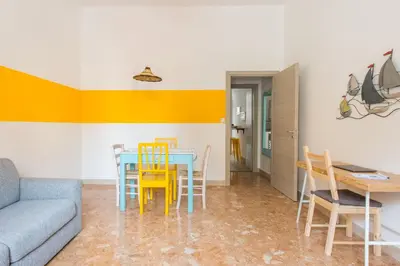 a living room with a table and chairs and a couch at Vento di Grecale - a pochi metri dal mare in Santa Flavia