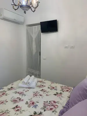 a room with a bed with a mirror and white shoes at Le Lanterne di Terrasini in Terrasini