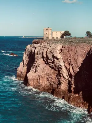 a lighthouse on top of a cliff in the ocean at Le Lanterne di Terrasini in Terrasini