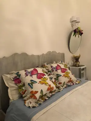a bedroom with a bed with two pillows and a mirror at Le Lanterne di Terrasini in Terrasini