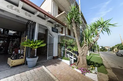 a store with palm trees in front of a building at Corleone GUESTHOUSE in Corleone