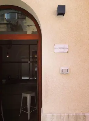 a sign on the side of a building with a stool at Mediterranea - Piccola Dimora per Viaggiatori in Castellammare del Golfo