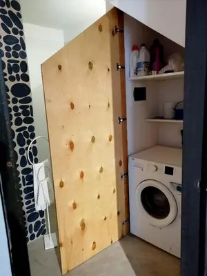 a bathroom with a wooden wall next to a washing machine at Mediterranea - Piccola Dimora per Viaggiatori in Castellammare del Golfo