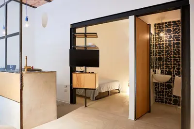 a bedroom with a bed and a television in a room at Mediterranea - Piccola Dimora per Viaggiatori in Castellammare del Golfo