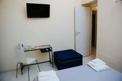 a room with a bed and a desk and a chair at Calamarina Centro in Palermo