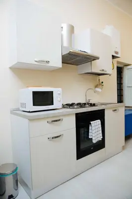 a kitchen with a microwave and a stove at Calamarina Centro in Palermo