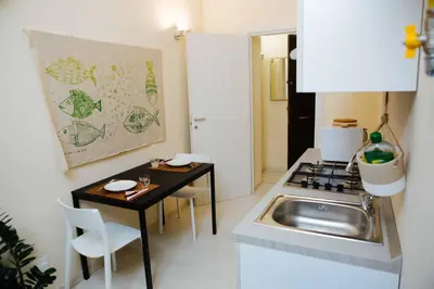 a small kitchen with a sink and a table at Calamarina Centro in Palermo
