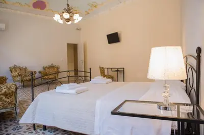 a bedroom with a bed with a table with a lamp at Calamarina Centro in Palermo
