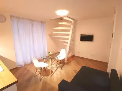 a living room with a spiral staircase and a table and chairs at Diatomea in Palermo