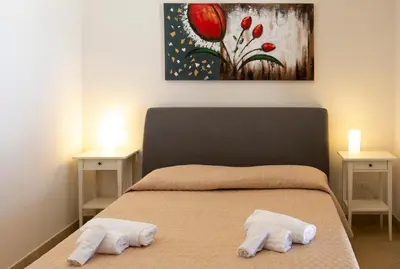 a bedroom with a bed with two towels on it at Boa Vista San Vito - Area Fitness, Barbecue Area, Tennis Court in San Vito lo Capo