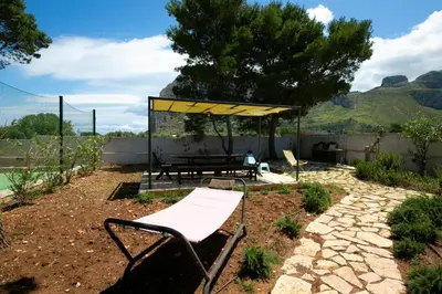 a picnic table and a bench in a garden at Boa Vista San Vito - Area Fitness, Barbecue Area, Tennis Court in San Vito lo Capo