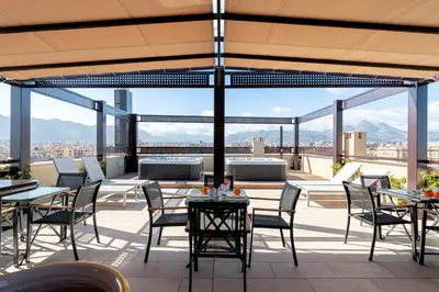 a patio with tables and chairs and a view of the city at Solemar Sicilia - Multi Suite in Palermo