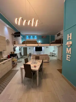 a living room with a table and a kitchen at Casa vacanza toledo in Partinico
