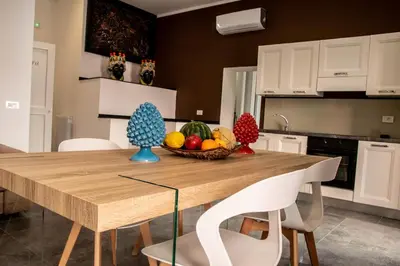 a kitchen with a wooden table with a bowl of fruit at Casta Diva Luxury Apartments -Self check-in in Palermo