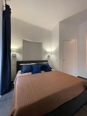 a bedroom with a large bed with blue pillows at Casta Diva Luxury Apartments -Self check-in in Palermo
