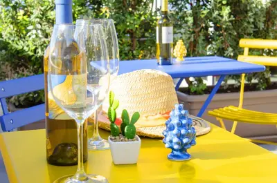 a table with two wine glasses and a hat on it at Solemare Casa Vacanze in Castellammare del Golfo