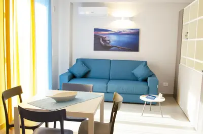 a living room with a blue couch and a table at Solemare Casa Vacanze in Castellammare del Golfo