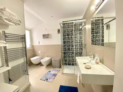 a bathroom with a toilet and a sink and a shower at Josh's House Mondello in Mondello