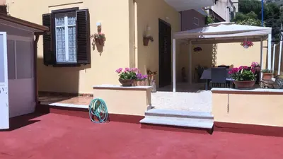 a house with two potted plants and an umbrella at Josh's House Mondello in Mondello