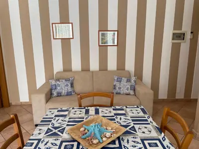 a living room with a table and a couch at Casa Vacanze Costanza in San Vito lo Capo
