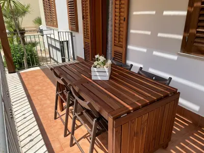 a wooden table and chairs on a patio at Casa Vacanze Costanza in San Vito lo Capo