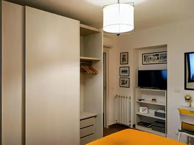 a room with a closet with a tv and a desk at Zisa Home ai Cantieri Culturali con Patio Privato - vicino centro storico - No ZTL in Palermo