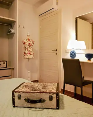 a room with a bed with a dresser and a chair at Zisa Home ai Cantieri Culturali con Patio Privato - vicino centro storico - No ZTL in Palermo