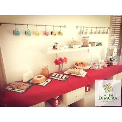 a table with a red counter top with food on it at B&B La Tua Dimora in Palermo