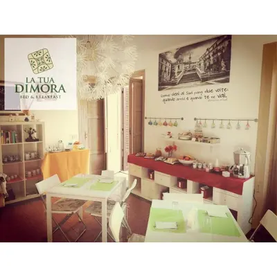 a dining room with a table and two tables and chairs at B&B La Tua Dimora in Palermo