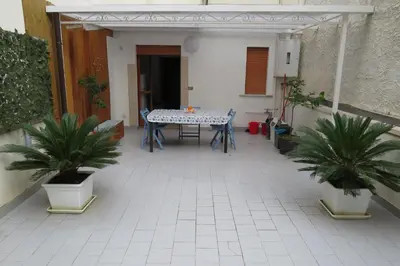 a patio with a table and two potted plants at Sofi apartment in Palermo